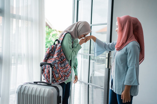daughter kisses her mother's hand when returning home, an Asian Muslim family