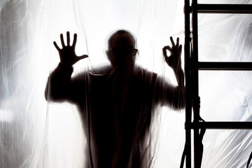 Fototapeta na wymiar silhouette of man behind a plastic