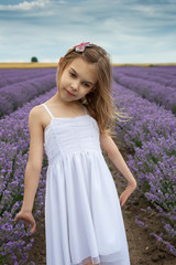 Fototapeta na wymiar Portrait of a little girl in a fully bloomed lavender field