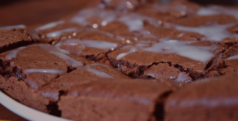 Chocolate brownie rests on a flat plate