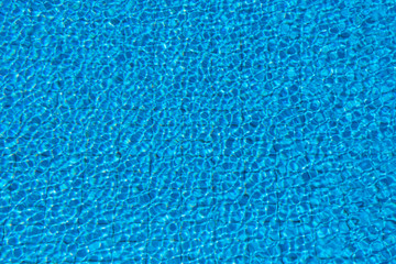 Fototapeta na wymiar Pure Blue Water In The Swimming Pool. Ripple And Waves In Clear Turquoise Water. Glare And Reflection, Water Pool Surface Background. Aqua Texture, Backdrop.