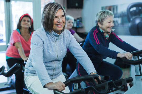 gruppo di donne anziane fa spinning in una palestra