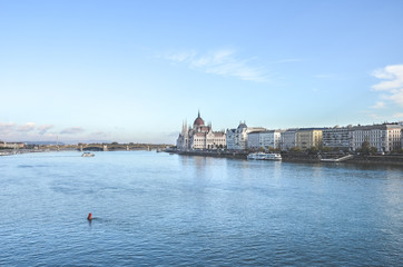 Danube river in Budapest, Hungary. Historical center with Hungarian Parliament building in the background by the river. Budapest cityscape with blue sky above. Eastern European cities
