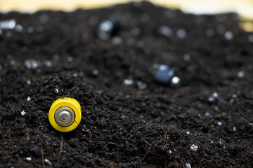Used batteries in the ground. Hazardous waste polluting the environment. The concept of...