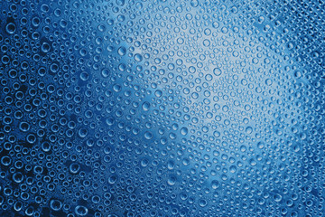 Condensate. Drops of water on a glass. Blue toned