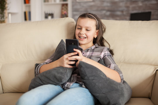 Teen girl with braces sitting on the couch in living room