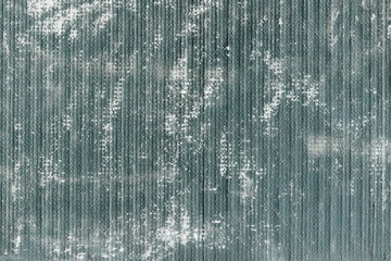 Grunge texture of a dull dark gray surface with dirt. Abstract background of dark muddy color with vertical stripes.