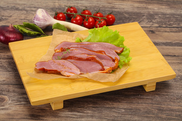 Sliced smoked duck breast served salad