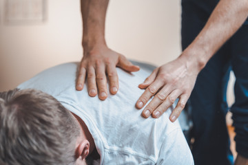 Physiotherapist treating shoulder of patient with a gentle massage