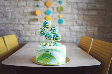 Holiday. Confectionery. Birthday. Celebratory multicolored  cake with mastic, meringue, with sweets on the table. Treats for guests.