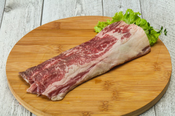 Raw beef bacon over wooden board