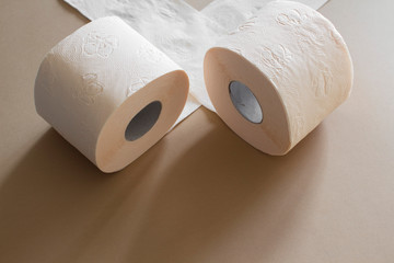 rolls of toilet paper peach beige color on beige background
