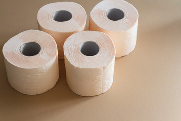 rolls of toilet paper peach beige color on beige background