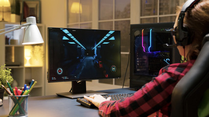 Female gamer with headphones playing shooter games © DC Studio