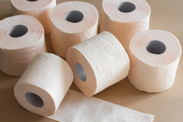 rolls of toilet paper peach beige color on beige background