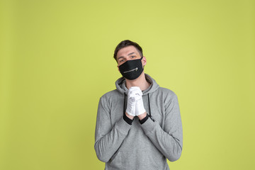 Cute posing. Caucasian man's portrait isolated on yellow studio background. Freaky male model in black face mask. Concept of human emotions, facial expression, sales, ad. Unusual appearance.