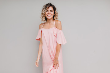 Glamorous girl with short curly hair posing with cute smile. Studio portrait of shapely caucasian...