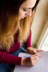 woman writing in a note book at home