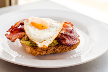 close up of avocado toast for breakfast with fried egg