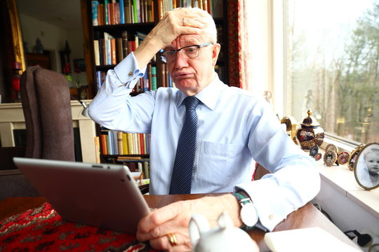 frustrated elderly man that doesn't know how to operate his computer