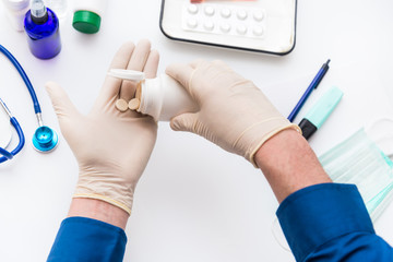 Fototapeta premium A man takes medications and vitamins, prevention and treatment of coronavirus