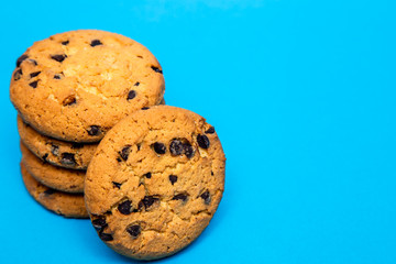 homemade cookies with pieces of chocolate for breakfast lies on a blue background.