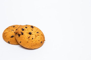 two homemade cookies with pieces of chocolate for breakfast lie on a white isolated background.