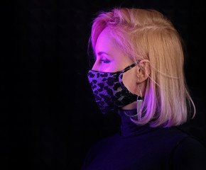 neon lights woman in surgical mask against coronavirus poses for fashion luxury shot, infected girl scared of epidemic disease covid-19 virus wearing mask, patient in mask isolated in black background