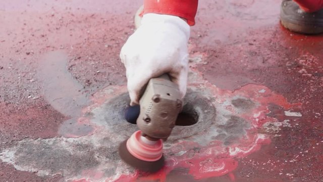 Process of derusting, paint and rust removal by pneumatic grinder from ship deck by vessel crew. Close up. Ship deck maintenance concept.