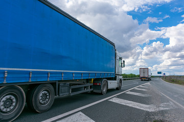 Fototapeta na wymiar Truck with canvas semi-trailer with side opening for general transport while driving on the highway