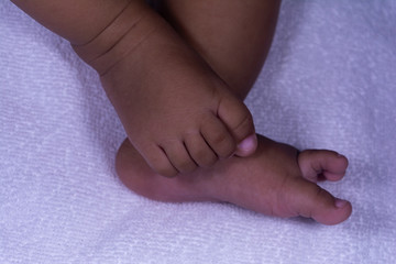 ASIAN BABY GIRL BEAUTIFUL LEGS IN A POSITION CLOSE VIEW WITH WHITE TOWEL BACKGROUND