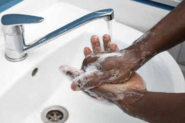 Fototapeta premium Man washing hands carefully with soap and sanitizer, close up. Prevention of pneumonia virus spreading, protection against coronavirus pandemia. Hygiene, sanitary, cleanliness, disinfection. Safety.