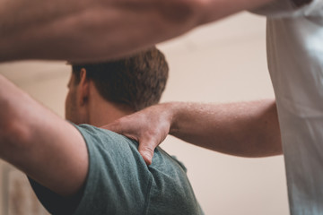 Physiotherapist treating patient for various physical ailments and giving shoulder a massage