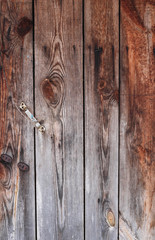 Background of dark brown old boards with a door handle.