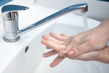 Woman washing hands carefully with soap and sanitizer, close up. Prevention of pneumonia virus spreading, protection against coronavirus pandemia. Hygiene, sanitary, cleanliness, disinfection. Safety.