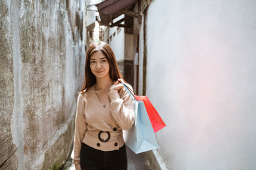 Woman shopping. Happy asian attractive woman with paper bags enjoy shopping. Consumerism, urban lifestyle concept