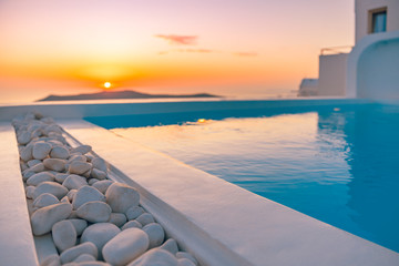 Fototapeta na wymiar Amazing sunset relaxing mood the pool in a luxurious hotel resort at sunset enjoying perfect beach holiday vacation. Summer landscape, beautiful sunset sky, banner concept of Santorini vacation