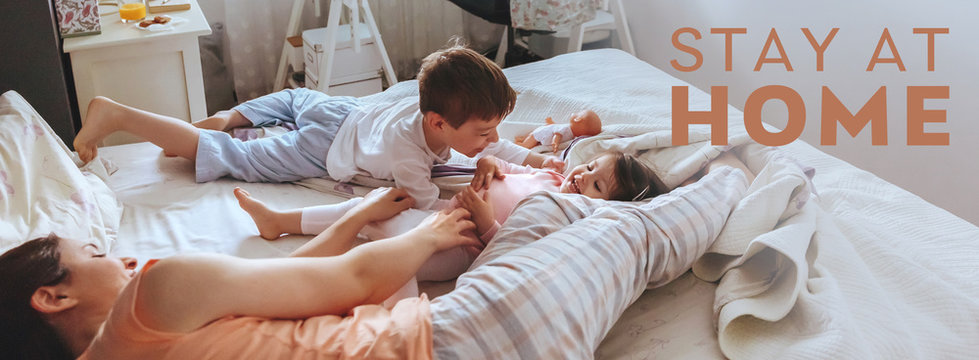 Portrait of happy family playing over the bed in a relaxed morning during virus confinement