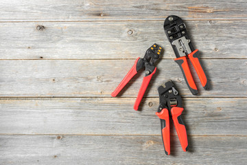 Tools for crimping stranded electrical wires. Crimping tools for electrician or Builder on a grey wooden background	