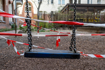 Corona crisis - Children's playground cordoned off with a red and white barrier tape in the...