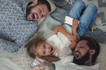 Male Couple Taking Selfies With Little Daughter
