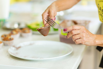 Fototapeta na wymiar Confectioner decorates a baking plate with cocoa powder