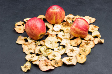 Tasty slices of dried apples, fresh red apples. Vegan snack.