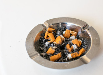 Ashtray full of cigarettes and ash close up.