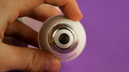 the light bulb in men's hands is plinth forward. on a purple background
