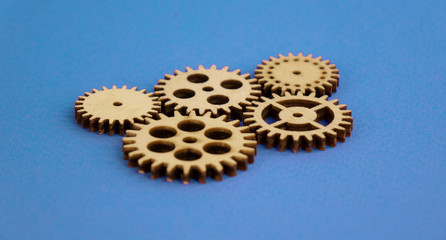 Wooden clock mechanism. lying on a blue background