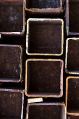 Copper pipes mixed with rusty pipes scattering background