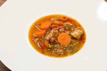 Guiso de lentejas en un plato redondo blanco. Vista superior y de cerca