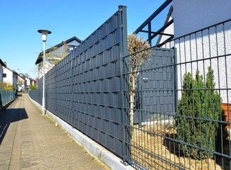 Abgrenzung eines Wohngrundstücks mit Kunststoff-Sichtschutzfolie an Stahlgitterzaun © Hermann