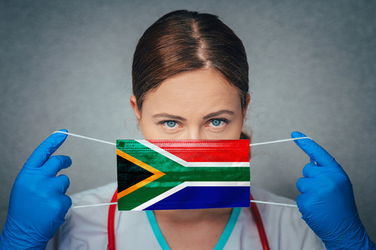 Coronavirus In South Africa Female Doctor Portrait Hold Protect Face Surgical Medical Mask With South Africa National Flag. Illness, Virus Covid-19 In South Africa, Concept Photo